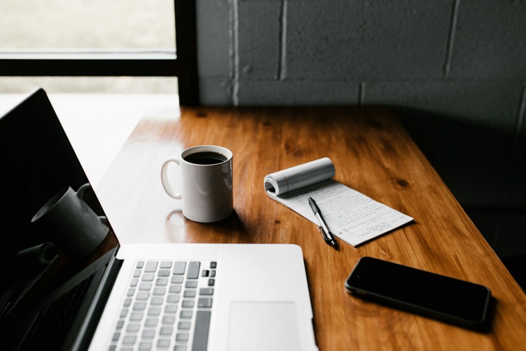 Bureau minimaliste de freelance avec laptop ouvert, mug de café et carnet de notes